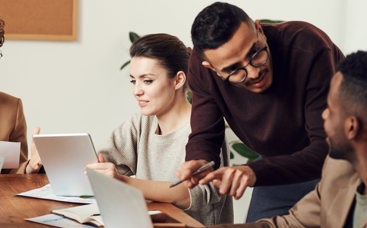 Three people on laptops and talking