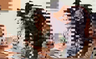 Three people on laptops and talking