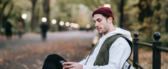 Man sitting on beach looking at his phone