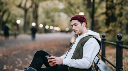 Man sitting on beach looking at his phone