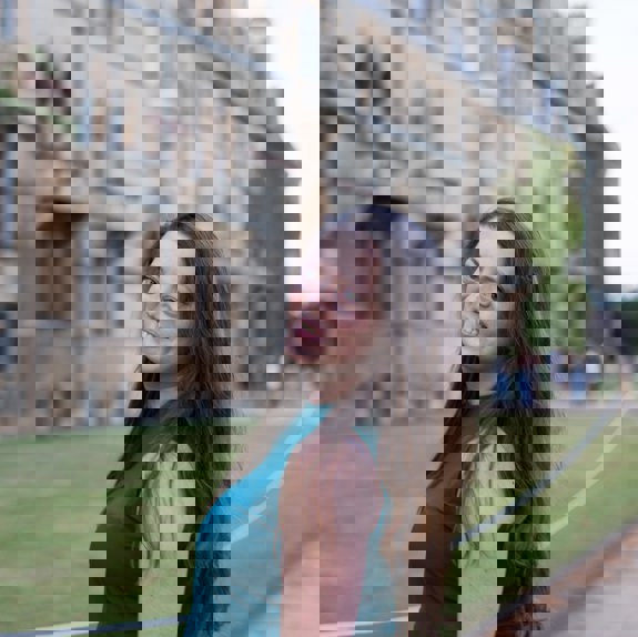 Woman smiling in front of university