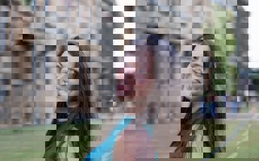 Woman smiling in front of university